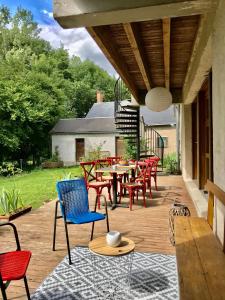 een patio met houten tafels en stoelen en een tafel en stoelen bij Le Moulin in Mesland