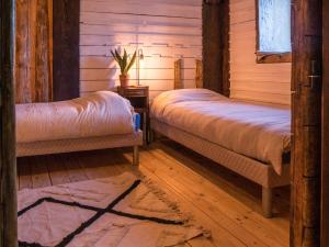 2 letti in una camera con pareti in legno e pavimenti in parquet di La luge a Cormaranche-en-Bugey
