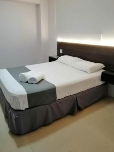 Una cama con dos toallas blancas encima. en Hotel 2 Mares, en Panamá