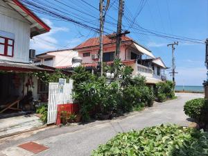 une maison dans une rue à côté de l'océan dans l'établissement ThaiMex Cafe & Homestay Backpackers- Adults Only, à Prachuap Khiri Khan