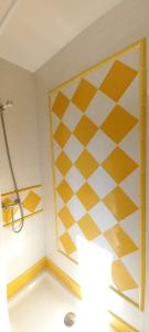 a bathroom with a yellow and white checkered wall at Posada la Vieja Escuela in San Roque de Ríomiera