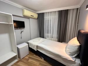 Habitación pequeña con cama y ventana en Asparagus HOTEL & SUITES OLD CITY, en Estambul