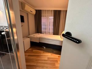 um pequeno quarto com uma cama e uma porta em Asparagus HOTEL & SUITES OLD CITY em Istambul
