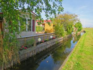 a house next to a canal with a house at dutchduochalet2 in Heenweg