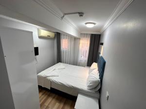 um pequeno quarto com uma cama e uma janela em Asparagus HOTEL & SUITES OLD CITY em Istambul