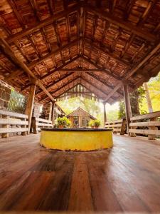 um grande edifício de madeira com um palco amarelo no meio em Green's Guest House em Auroville