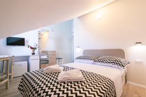 a bedroom with a bed with a black and white comforter at Hotel ROYAL RINA in Stomorska