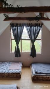 duas camas num quarto com duas janelas em Kuća za odmor/Party kuća em Lukinić Senovec