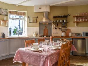 a kitchen with a table with a table cloth on it at St, Georges Cottage in Holmfirth