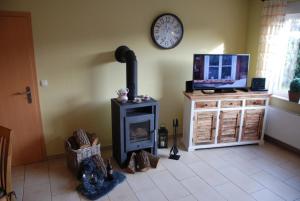 sala de estar con chimenea y reloj en la pared en Haus Christiane, en Berumbur