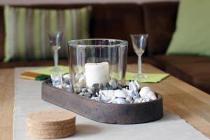una bandeja con una vela y rocas en una mesa en Haus Christiane, en Berumbur