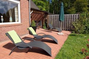 - deux chaises et un parasol sur une terrasse en briques dans l'établissement Haus Christiane, à Berumbur