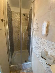 W łazience znajduje się prysznic ze szklanymi drzwiami. w obiekcie Hotel Pension Bella w Berlinie