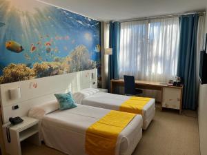 a hotel room with two beds and an aquarium mural at Hotel Sporting Brugherio in Brugherio