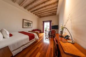 a bedroom with a bed and a desk in a room at Hotel Boutique Casa San Diego in Morelia