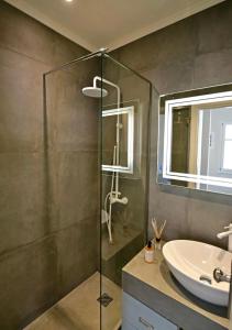 a bathroom with a glass shower and a sink at NESEA Boutique Apartments in Hydra