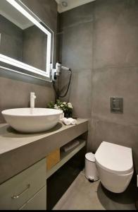 a bathroom with a white sink and a toilet at NESEA Boutique Apartments in Hydra