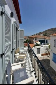 a balcony with a table and chairs on a house at NESEA Boutique Apartments in Hydra
