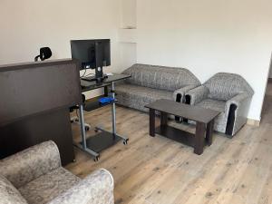 a living room with couches and a flat screen tv at Marigold Hotel in Siliguri