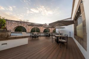 an outdoor deck with tables and chairs and umbrellas at Hotel Boutique Casa San Diego in Morelia