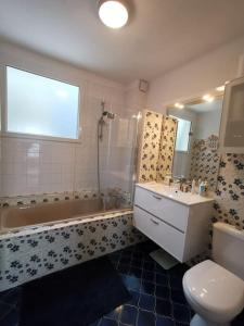 a bathroom with a sink and a tub and a toilet at Charme et zénitude, avec vue exceptionnelle sur le port in Granville