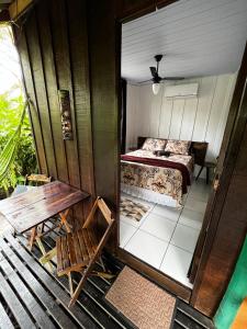 a room with a bed and a wooden table at Marema Pousada in Ilha do Mel
