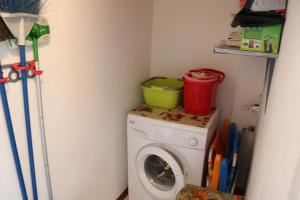 a washing machine with a bucket on top of it at ROSSINI APARTMENT FRONTE MARE in Follonica