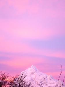 una montaña cubierta de nieve bajo un cielo rosa en Casa Olivia en Ushuaia