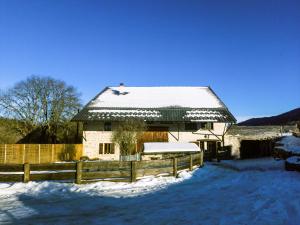 una casa con tetto ricoperto di neve e recinzione di La luge a Cormaranche-en-Bugey