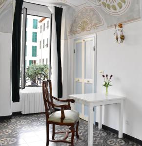 Una mesa blanca y una silla en una habitación con ventana en Appartamento magico nel centro del borgo L'ancora., en Laigueglia