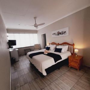 a bedroom with a large bed and a television at Acorn Lodge & SKYDECK in Potchefstroom