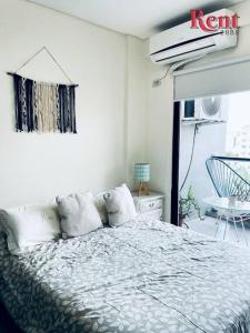 Un dormitorio con una cama con almohadas. en Rent Corrientes y Lambaré en Buenos Aires