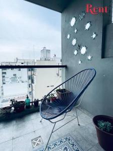 Una silla en una habitación con una pared con pájaros. en Rent Corrientes y Lambaré en Buenos Aires