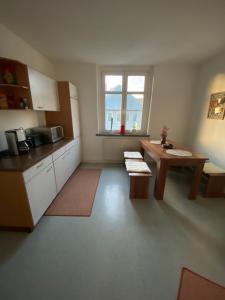 Zimmer mit einer Küche mit einem Tisch und einem Fenster in der Unterkunft Geräumige Ferienwohnung im Grünen in Lichtenstein