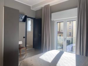 a bedroom with a bed and a large window at Hotel Graziella in Arma di Taggia