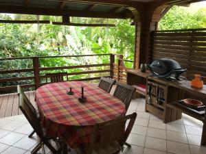 - une table et des chaises sur une terrasse couverte avec une table dans l'établissement Banan Woz, à Bouillante