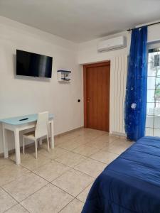 a bedroom with a desk and a table and a tv at Pepe rosa in Termoli