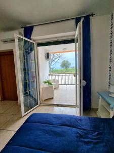 a bedroom with a blue bed and a sliding glass door at Pepe rosa in Termoli