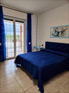 a bedroom with a blue bed and a sliding glass door at Pepe rosa in Termoli