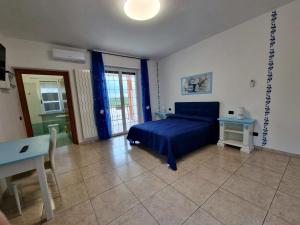 Un dormitorio con una cama azul y una mesa en Pepe rosa, en Termoli