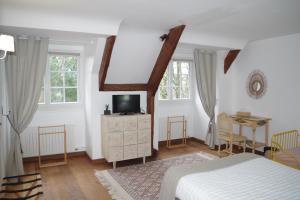 Schlafzimmer mit einem Bett, einem Schreibtisch und Fenstern in der Unterkunft Bed and Breakfast Saultchevreuil, au Mont Saint Michel in Villedieu-les-Poëles