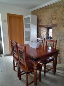 a wooden table with chairs and a white bowl on it at Casa Elizabeth in Pedrógão Grande
