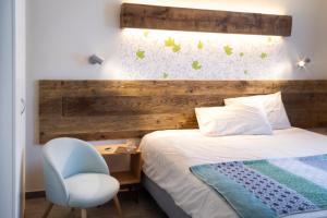 um quarto com uma cama com uma cabeceira de madeira e uma cadeira em Hirondelle Locanda em Aosta