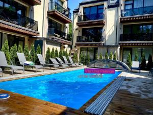a swimming pool in front of a building at Vila Una Palanga in Palanga