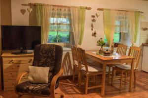 a dining room with a table and chairs and a television at Penzion Adršpach " U Kozárů " in Teplice nad Metují