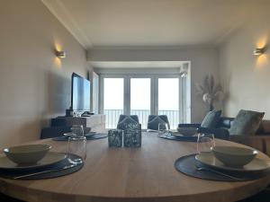 a living room with a wooden table with plates on it at Casino Beach in Middelkerke