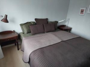 ein Schlafzimmer mit einem Bett mit zwei Tischen und einem Sofa in der Unterkunft Vesteby Hus - a peaceful stay in the countryside! in Grästorp
