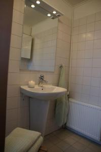 ein Bad mit einem Waschbecken und einem Spiegel in der Unterkunft Vesteby Hus - a peaceful stay in the countryside! in Grästorp