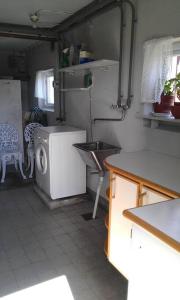 eine kleine Küche mit Spüle und Waschmaschine in der Unterkunft Vesteby Hus - a peaceful stay in the countryside! in Grästorp