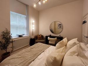 1 dormitorio con cama, espejo y escritorio en Luxury 2 Bedroom Flat in Central Todmorden en Todmorden